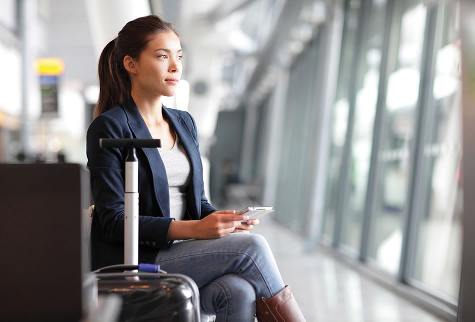 Person with carry-on baggage sitting in airport terminal